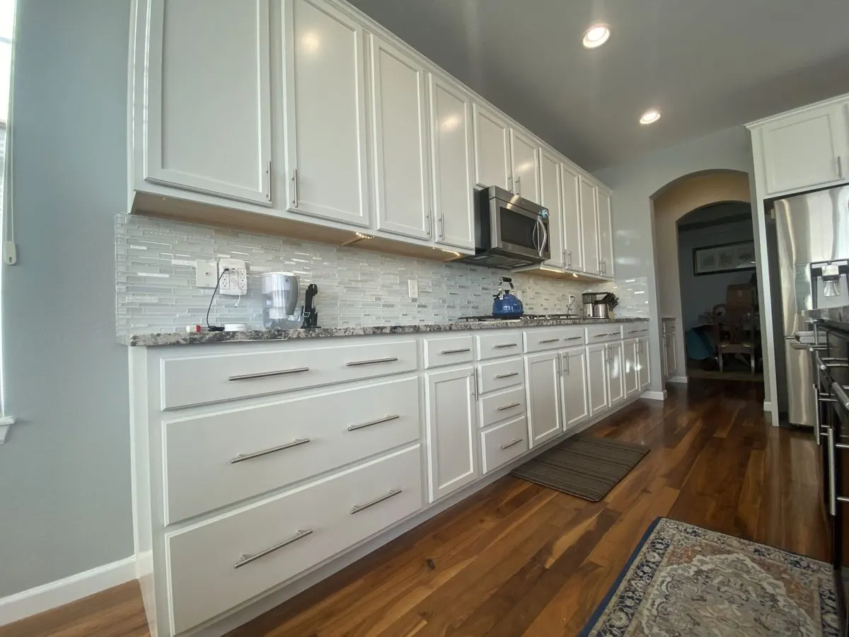 Long run of white repainted cabinets with new hardware